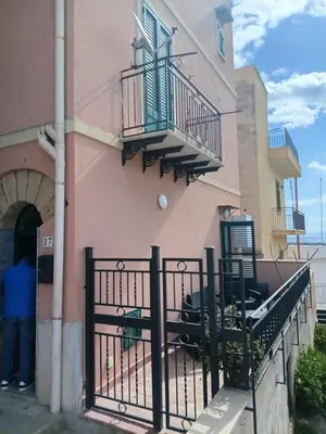 a man standing in front of a building with a fence at Case Nereidi 1 in Porticello