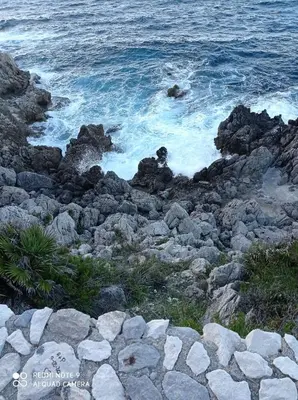 a group of rocks on the shore of the ocean at Case Nereidi 2 in Porticello