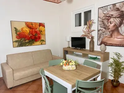 a living room with a table and a couch at Mercury Apartment - 100 mq nel cuore di Palermo in Palermo