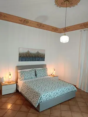 a bedroom with a bed and two tables with lamps at Mercury Apartment - 100 mq nel cuore di Palermo in Palermo
