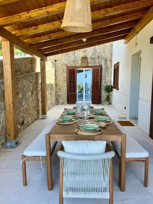 a wooden table with white chairs and a dining room at Villa Anthea - Relax vista mare tra Palermo e Cefalù in Trabia