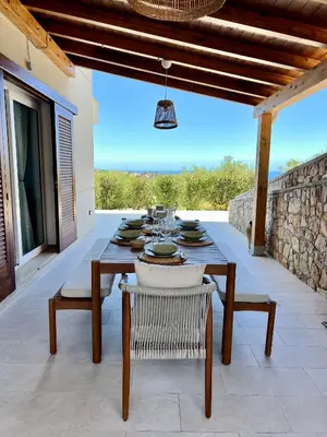 a wooden table and chairs on a patio at Villa Anthea - Relax vista mare tra Palermo e Cefalù in Trabia
