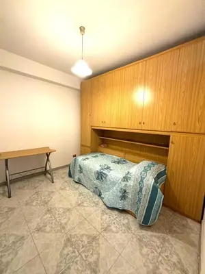 a bedroom with a bed and a wooden wall at Nelly's house in Terrasini