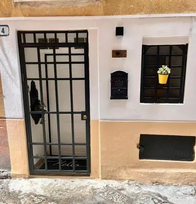 a building with a door and a window with a flower pot at La dolce casa in Palermo