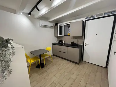 a small kitchen with a table and a door at La dolce casa in Palermo