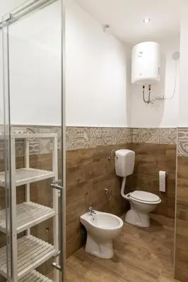 a bathroom with a toilet and a glass shower stall at GAle Apartment in Palermo