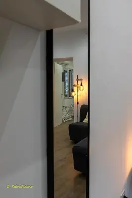 a mirror in a living room looking into a room at GAle Apartment in Palermo