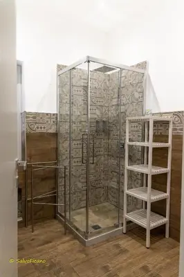 a glass shower with a ladder in a room at GAle Apartment in Palermo