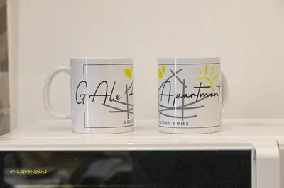 two coffee mugs sitting on top of a microwave at GAle Apartment in Palermo
