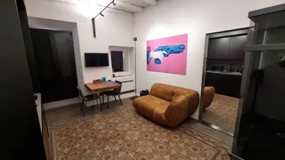 a living room with a chair and a table at Suitt Drims 8 in Palermo