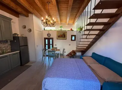 a room with a bed and a kitchen and a staircase at Cortile Cipriani in Palermo
