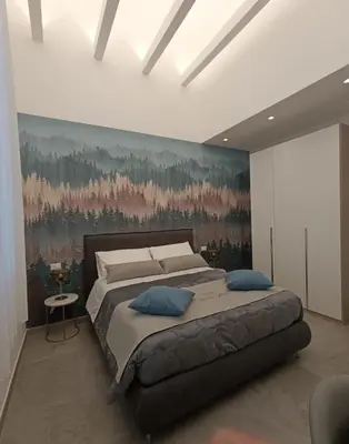 a bedroom with a large bed with a painting on the wall at Home Luxury Felice Marine in Palermo