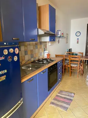 a blue kitchen with a sink and a stove at San Vito Suite Apartament in San Vito lo Capo