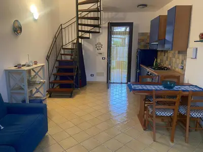 a living room with a blue couch and a table at San Vito Suite Apartament in San Vito lo Capo