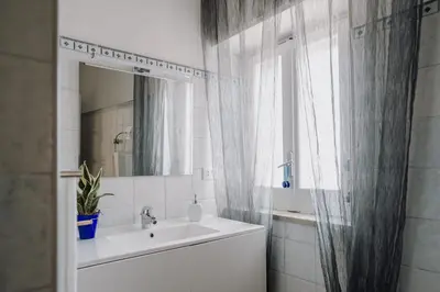 a bathroom with a sink and a mirror and a window at La Perla d'Argento in Santa Flavia