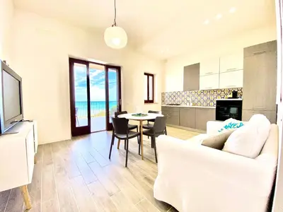 a living room with a white couch and a table at Riva Marina, sulla spiaggia in Alcamo