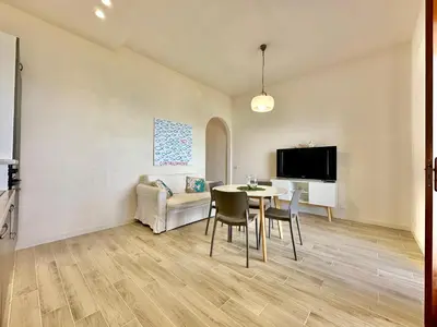 a living room with a table and chairs and a tv at Riva Marina, sulla spiaggia in Alcamo