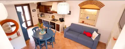 a living room with a blue couch and a table at Anemos Apartment - Villa Sole in Macari