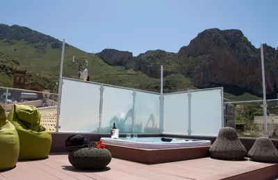 a hot tub sitting on top of a deck with mountains at Anemos Apartment - Villa Sole in Macari