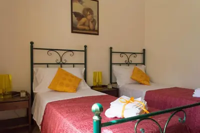 a bedroom with two beds and a picture on the wall at Anemos Apartment - Villa Stella in Macari