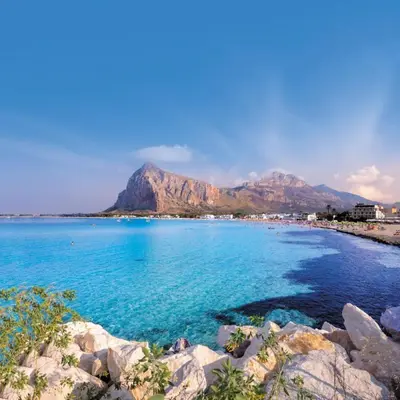 a yard with palm trees and a building at La perla marina casa vacanza in San Vito lo Capo