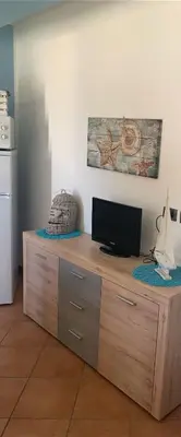 a wooden cabinet with a television on top of it at La perla marina casa vacanza in San Vito lo Capo