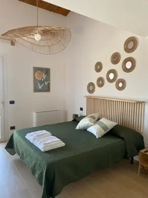 a bedroom with a green bed with towels on it at Villa Clori in Trabia