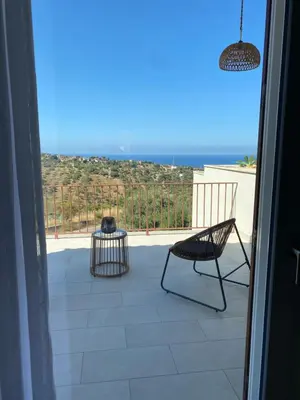 a balcony with a chair and a view of the ocean at Villa Clori in Trabia