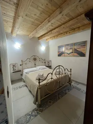 a bedroom with a bed and a wooden ceiling at Maddy Luxury Apartment in Palermo