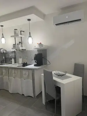 a kitchen with a counter and a table with chairs at Maddy Luxury Apartment in Palermo