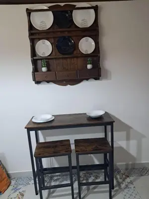 a table with two chairs and plates on a wall at Maddy Luxury Apartment in Palermo