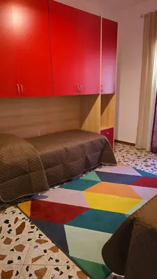 a bedroom with a bed and a colorful rug on the floor at Casa U' Rittu Filu in Bagheria