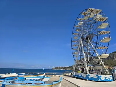 a ferris wheel and boats on a beach at Casa U' Rittu Filu in Bagheria