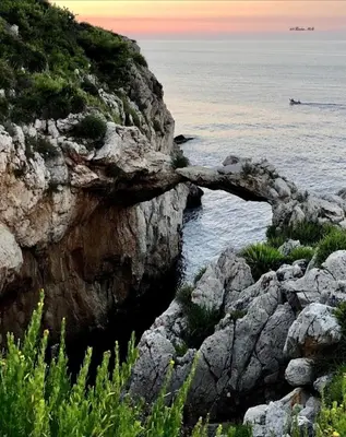 a rocky shoreline with a boat in the water at Casa U' Rittu Filu in Bagheria