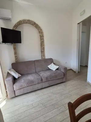 a brown couch sitting in a living room at I Vicini di Ballarò in Palermo