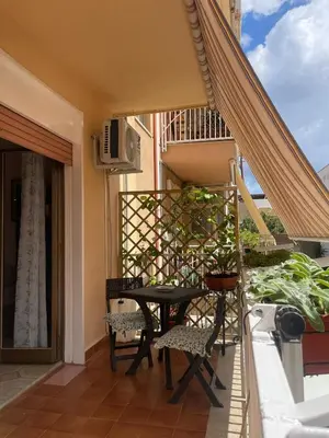 a patio with a table and chairs on a balcony at Casa MIUZZA in Isola delle Femmine