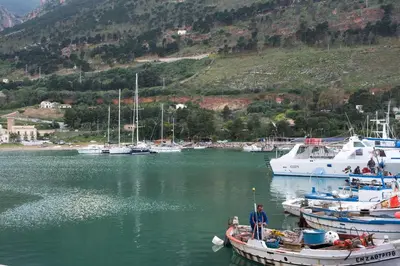 a man standing on a boat in a harbor at Casa De Gasperi in Castellammare del Golfo