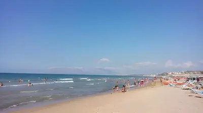 a group of people on a beach near the ocean at Casa De Gasperi in Castellammare del Golfo