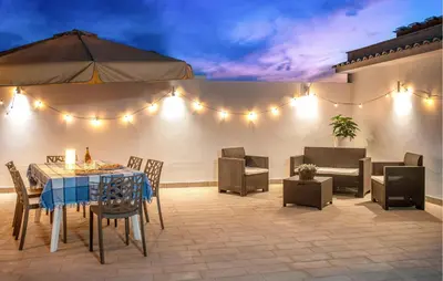 a patio with a table and chairs and lights at Beautiful Apartment In Balestrate in Balestrate