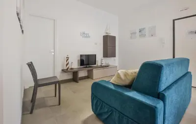 a living room with a blue chair and a couch at Beautiful Apartment In Balestrate in Balestrate