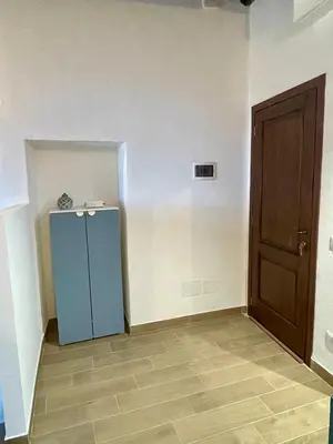 an empty room with a blue refrigerator and a door at Loft Al Baglio del Gelso in Balestrate