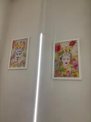 two pictures of a woman on a white wall at Giulia's Apartment in Altavilla Milicia