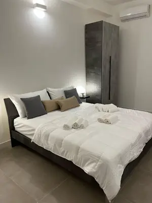 a large white bed with two towels on it at Helios Apartaments in Cinisi