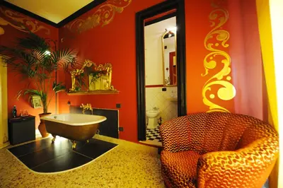 a bathroom with a claw foot tub and a chair at Sultan Suites in Palermo