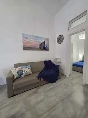 a living room with a couch and a bed at Giomasue' in Porticello