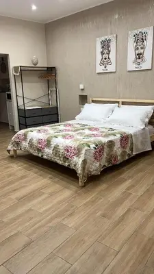 a large bed in a bedroom with a wooden floor at Infiniti noi home in Palermo