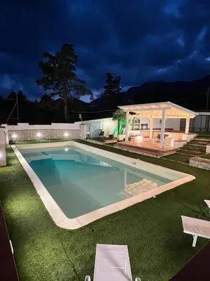 a large swimming pool in a yard at night at Villa Casty with private pool in Trabia