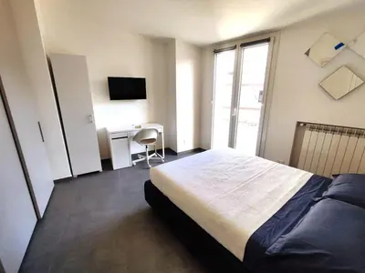 a bedroom with a bed and a desk with a television at QASA apartment with terrace, Palermo center in Palermo