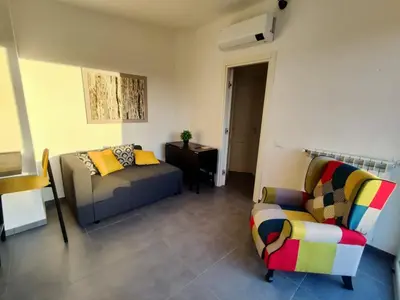 a living room with a couch and a chair at QASA apartment with terrace, Palermo center in Palermo