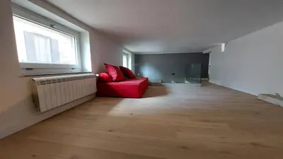 an empty living room with a red couch and a window at AntoX3 in Palermo